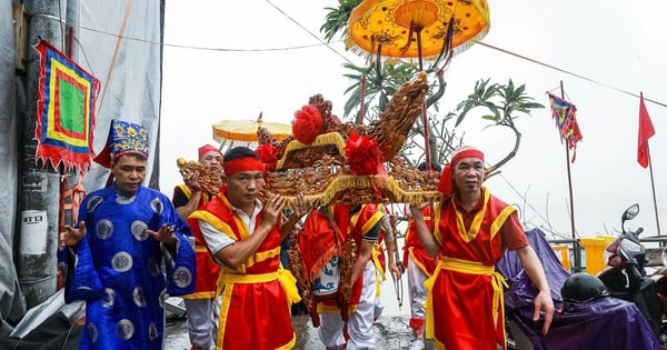 Người dân làng cổ Bát Tràng đi thuyền rước nước trên sông Hồng dưới cơn mưa phùn nhẹ