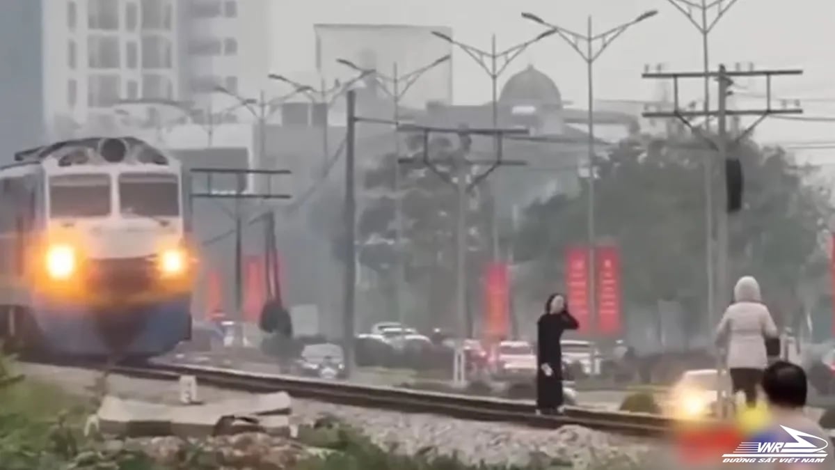 Freinage extraordinaire du conducteur de train devant 2 femmes posant sur les voies