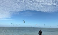 Touristen sind verrückt nach Kitesurfen am Strand von Ninh Thuan