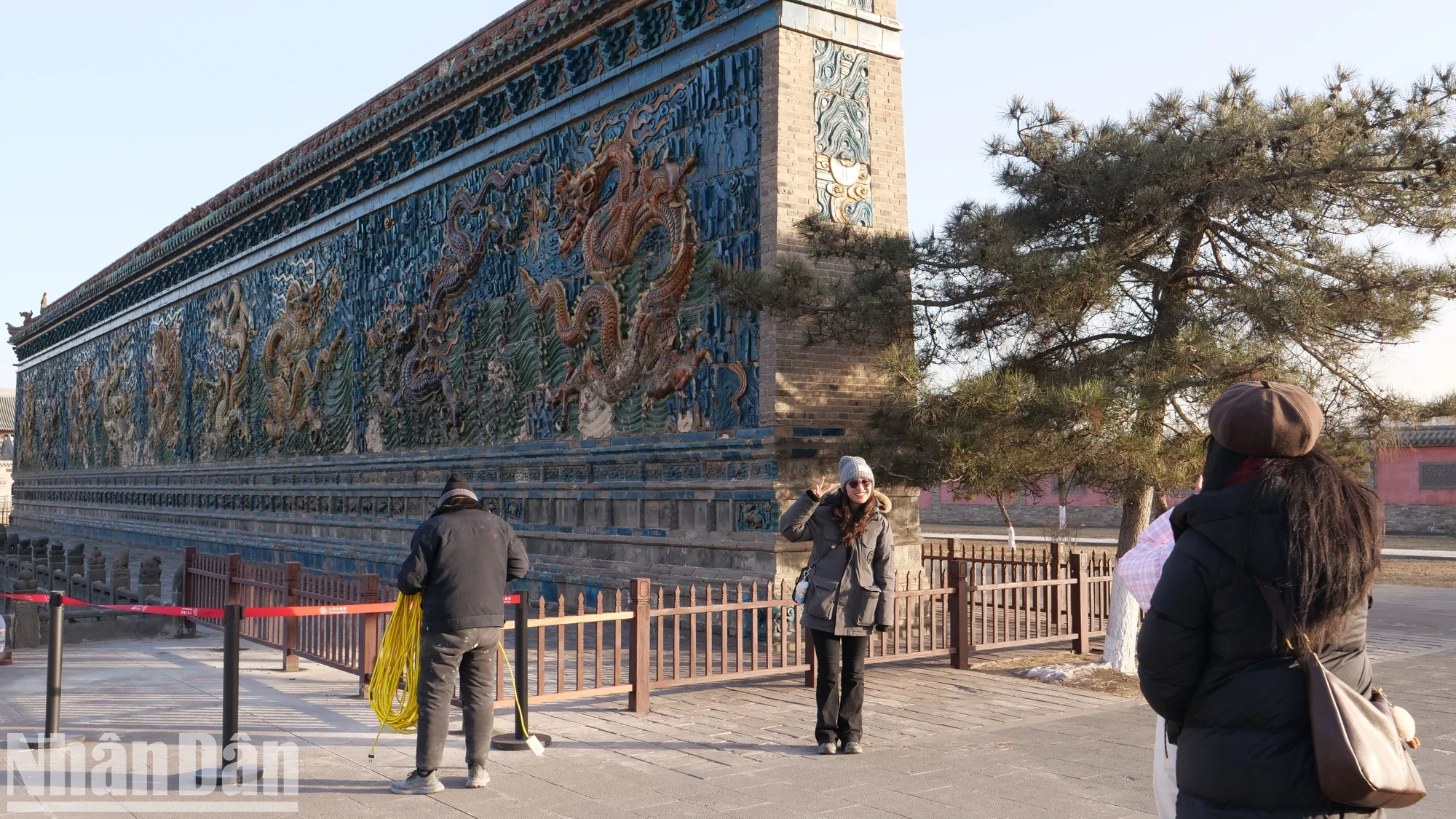 La façade principale des Neuf Dragons est recouverte de 426 tuiles émaillées spéciales de cinq couleurs, créant une image de neuf dragons se détachant sur un fond de montagnes, de rivières, de fleurs et d'herbe. Devant, un lac rectangulaire sur lequel neuf dragons peuvent se refléter. Lorsque la surface de l'eau ondule, l'image des neuf dragons semble jouer avec les nuages ​​et glisser dans le vent dans le ciel élevé.