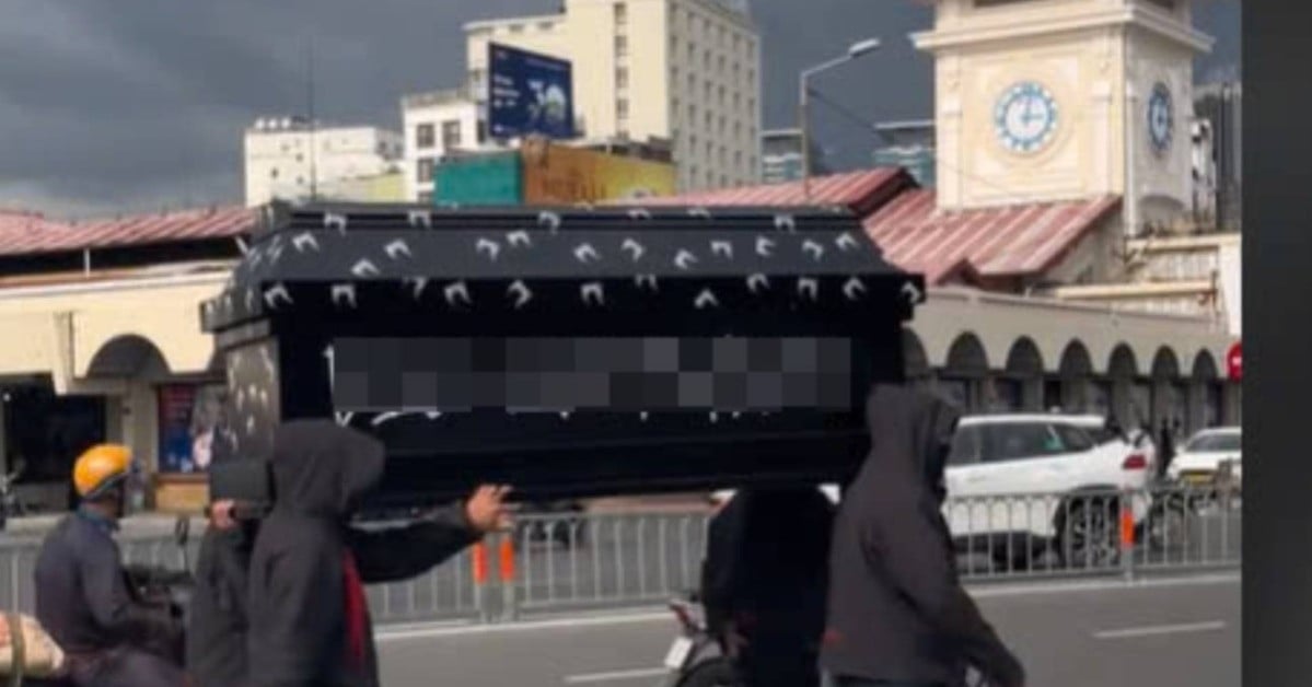 Groupe de jeunes hommes portant des cercueils devant le marché de Ben Thanh