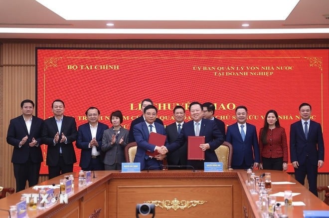 Signing ceremony to transfer the rights and responsibilities of the agency representing the State capital owner from the State Capital Management Committee at Enterprises to the Ministry of Finance. (Photo: Pham Hau/VNA)