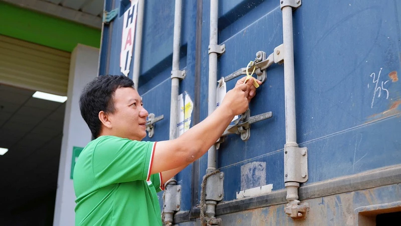 Ông Nguyễn Hữu Vinh - Giám đốc Công ty cổ phần IPP Sachi, khóa niêm phong container bánh tráng Sachi trước khi xuất xưởng sang Hoa Kỳ.