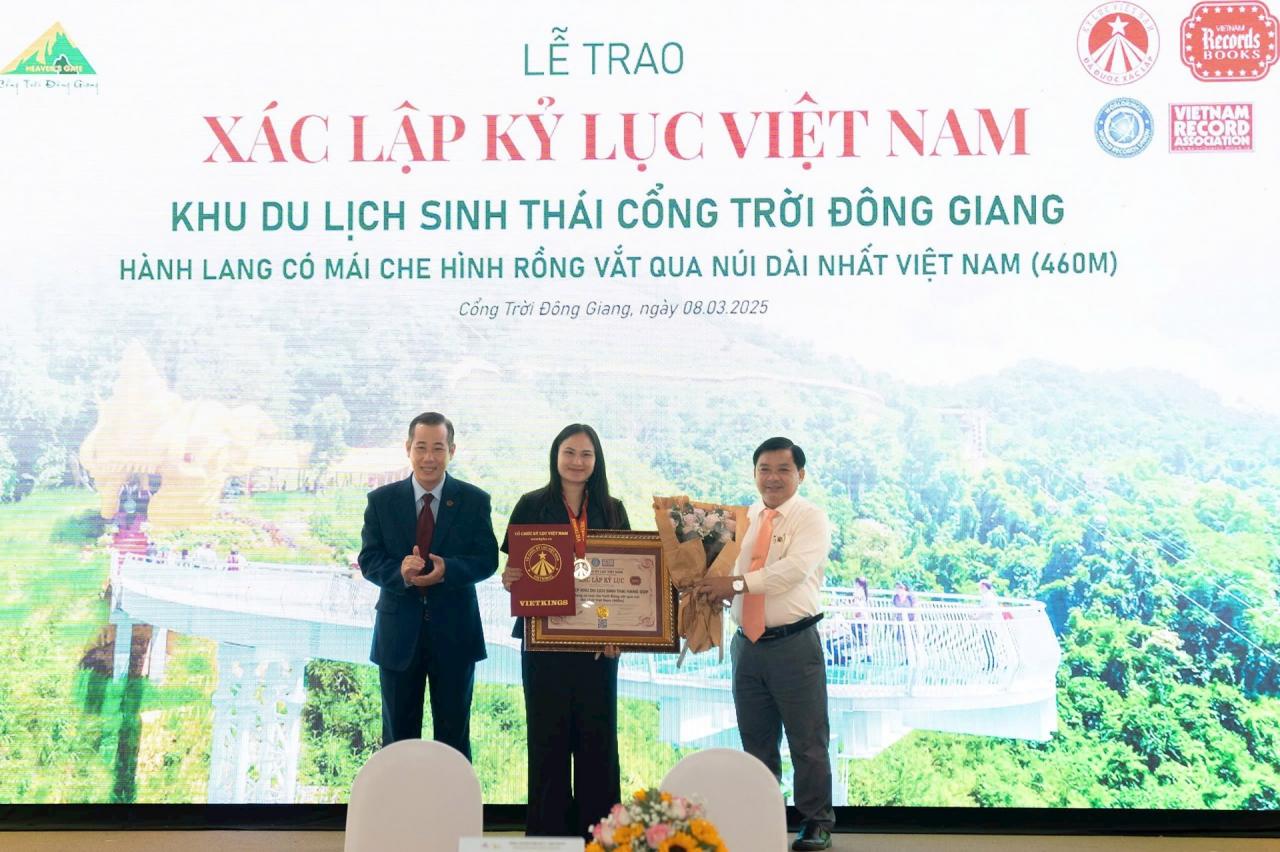 Đại diện Tổ chức kỷ lục Việt Nam trao bằng xác lập kỷ lục hành lang hình rồng dài nhất Việt Nam cho đại diện Khu du lịch sinh thái Cổng Trời Đông Giang. Ảnh: QUỐC TUẤN