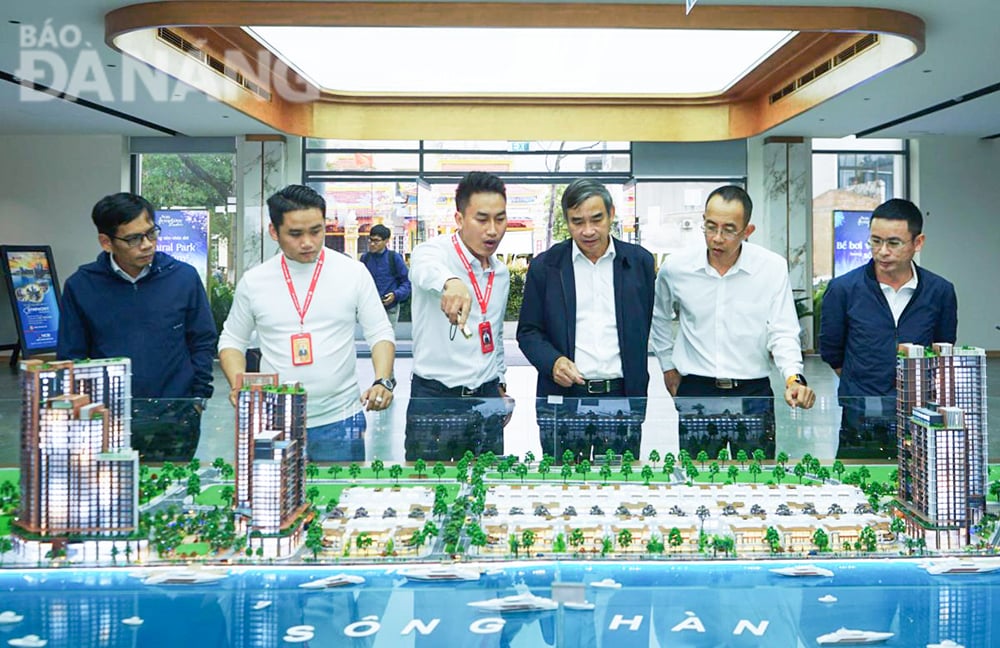 Chairman of the City People's Committee Le Trung Chinh (third from right) listens to a progress report on the Olalani Riverside Tower Complex Project. Photo: P.V