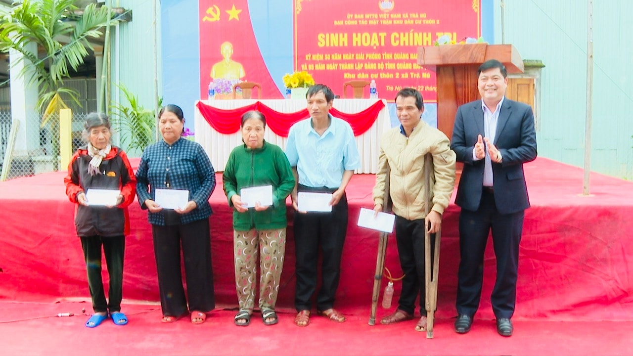 Head of the Provincial Party Committee's Internal Affairs Committee Nguyen Manh Ha presents gifts to disadvantaged families in the village. PHOTO: THUY VAN