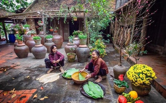 Các cụ bà sửa soạn gói bánh chưng bên ngôi nhà cổ ở Làng cổ Đường Lâm. (Ảnh: Ngọc Diệp)