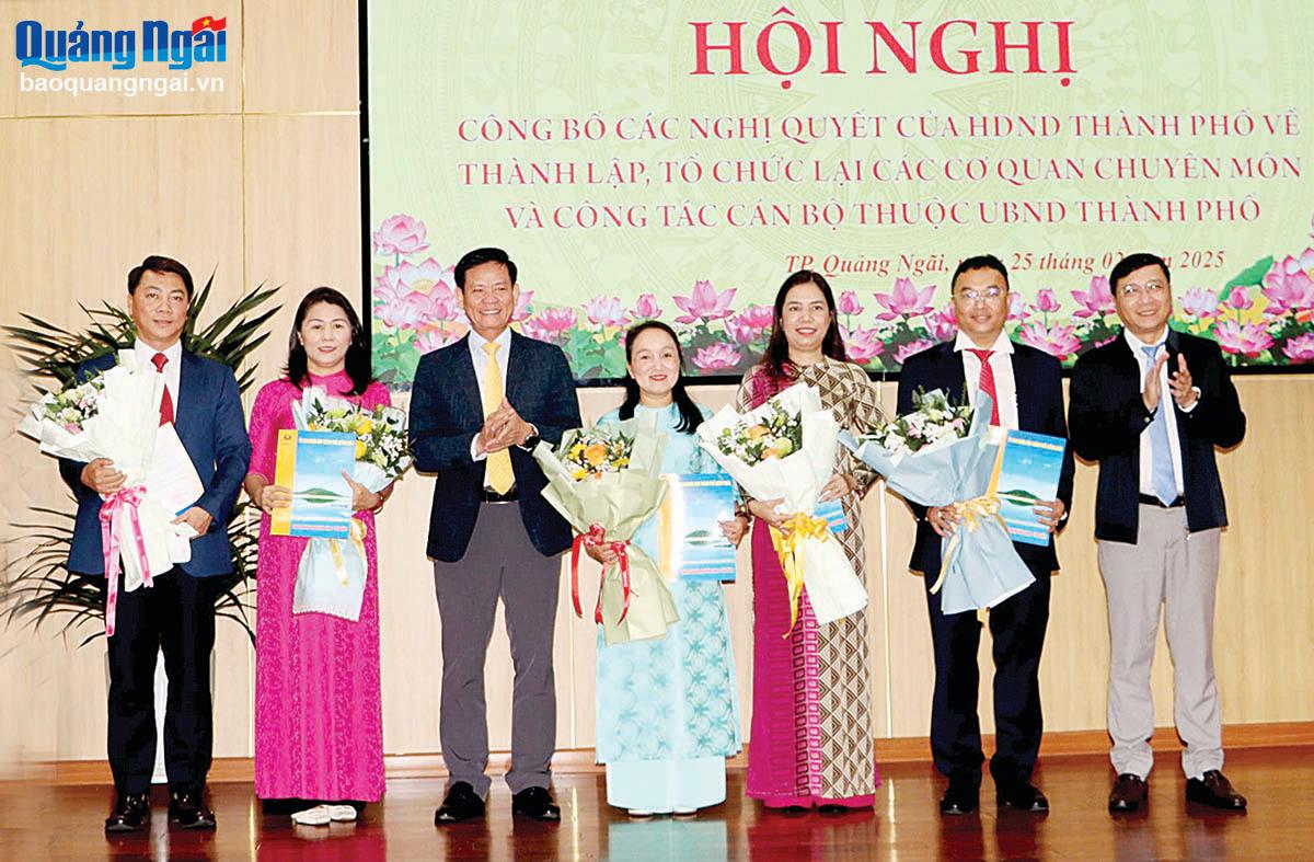 꽝응아이시 지도자들은 시인민위원회 산하 새로 개편된 전문기관 지도자들을 축하하기 위해 결정 사항과 꽃다발을 전달했습니다. 사진: 후 단