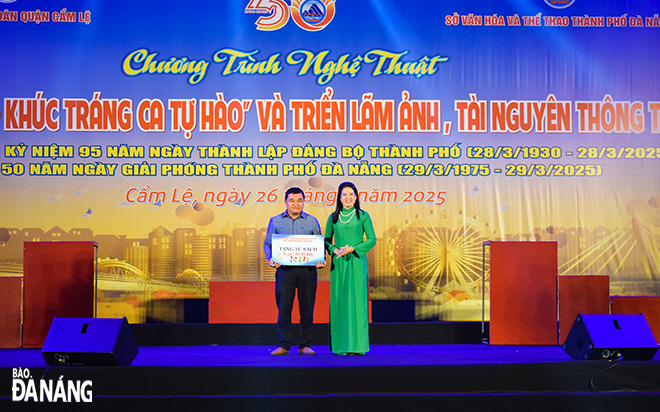 Đại diện Thư viện Khoa học tổng hợp Đà Nẵng trao bẳng tượng trưng tủ sách cộng đồng cho Trung tâm Văn hóa, thông tin và thể thao quận. Ảnh: ĐOÀN HẠO LƯƠNG