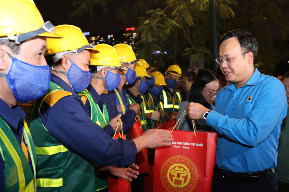 Chủ tịch Liên đoàn Lao động TP Hà Nội Phạm Quang Thanh tặng quà cho công nhân lao động đang thực hiện nạo vét sông Tô Lịch trong đêm - Ảnh: Mai Quý