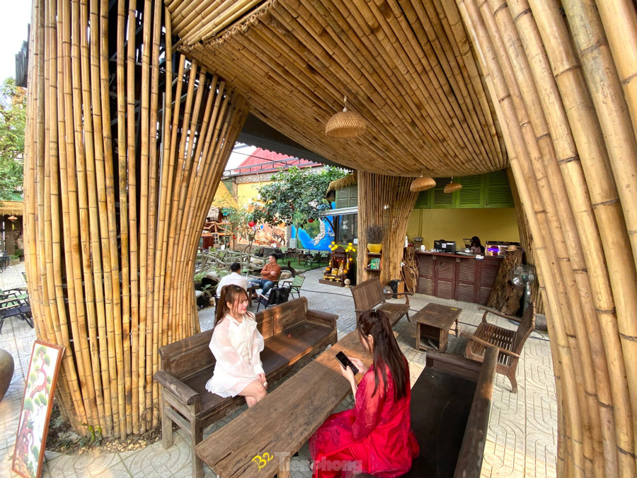 Bên dưới thân voi được đặt những chiếc bàn gỗ để mọi người uống cafe.