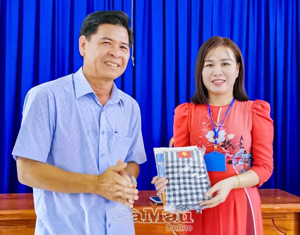 까마우성 문학예술협회 회장이자 시나리오 작가인 찐 타인 부(Trinh Thanh Vu) 씨가 보티홍 고등학교 글쓰기 현장 학습에서 후인 손 까(Huynh Son Ca) 선생님께 기념품을 선물했습니다. (사진: 황푹)