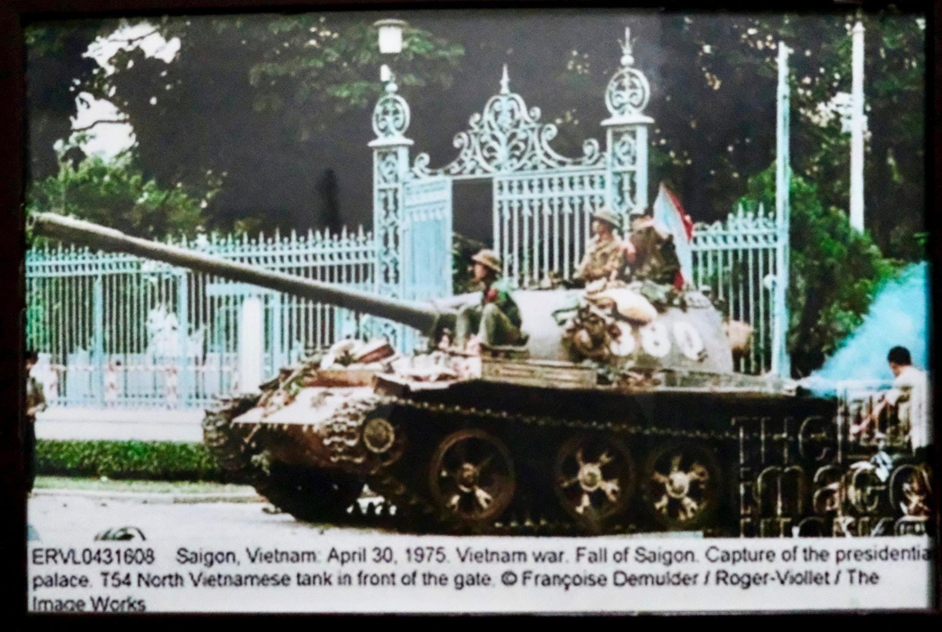 រថក្រោះ 380 បើកបរដោយលោក Nguyen Khac Nguyet បានឆ្លងកាត់ក្លោងទ្វារវិមានឯករាជ្យ។ រូបថត​នេះ​ត្រូវ​បាន​អ្នក​យក​ព័ត៌មាន​បារាំង​ថត​នៅ​ថ្ងៃ​ត្រង់​ថ្ងៃ​ទី​៣០ ខែ​មេសា ឆ្នាំ​១៩៧៥ ហើយ​បច្ចុប្បន្ន​ត្រូវ​បាន​លោក Nguyet ព្យួរ​នៅ​ផ្ទះ​ឯកជន​របស់​លោក​ក្នុង​ទីក្រុង​ហាណូយ។