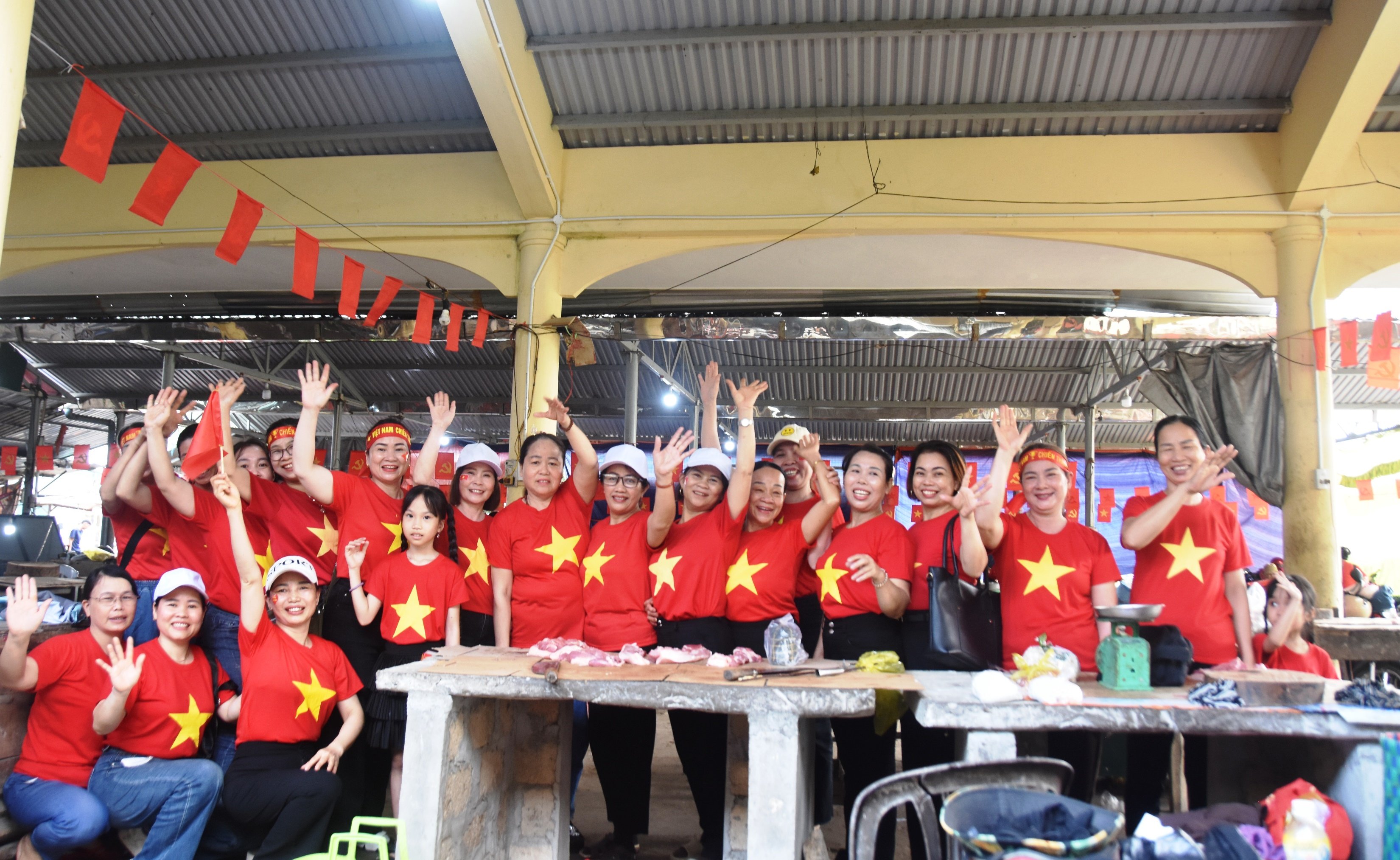 អាជីវករផ្សារ Lai Phuoc រាប់រយនាក់ពាក់អាវក្រហមជាមួយតារាពណ៌លឿង ដើម្បីអបអរសាទរពិធីបុណ្យដ៏អស្ចារ្យរបស់ប្រទេស។