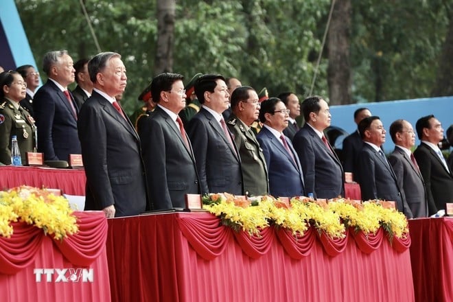 Các đồng chí lãnh đạo Đảng, Nhà nước và khách quốc tế thực hiện nghi thức chào cờ. (Ảnh: TTXVN)