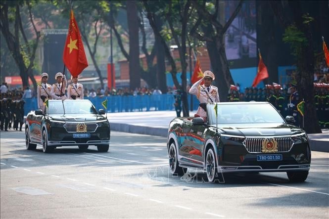 Xe chỉ huy và xe Tổ Công an kỳ - lực lượng công an nhân dân tiến qua lễ đài
