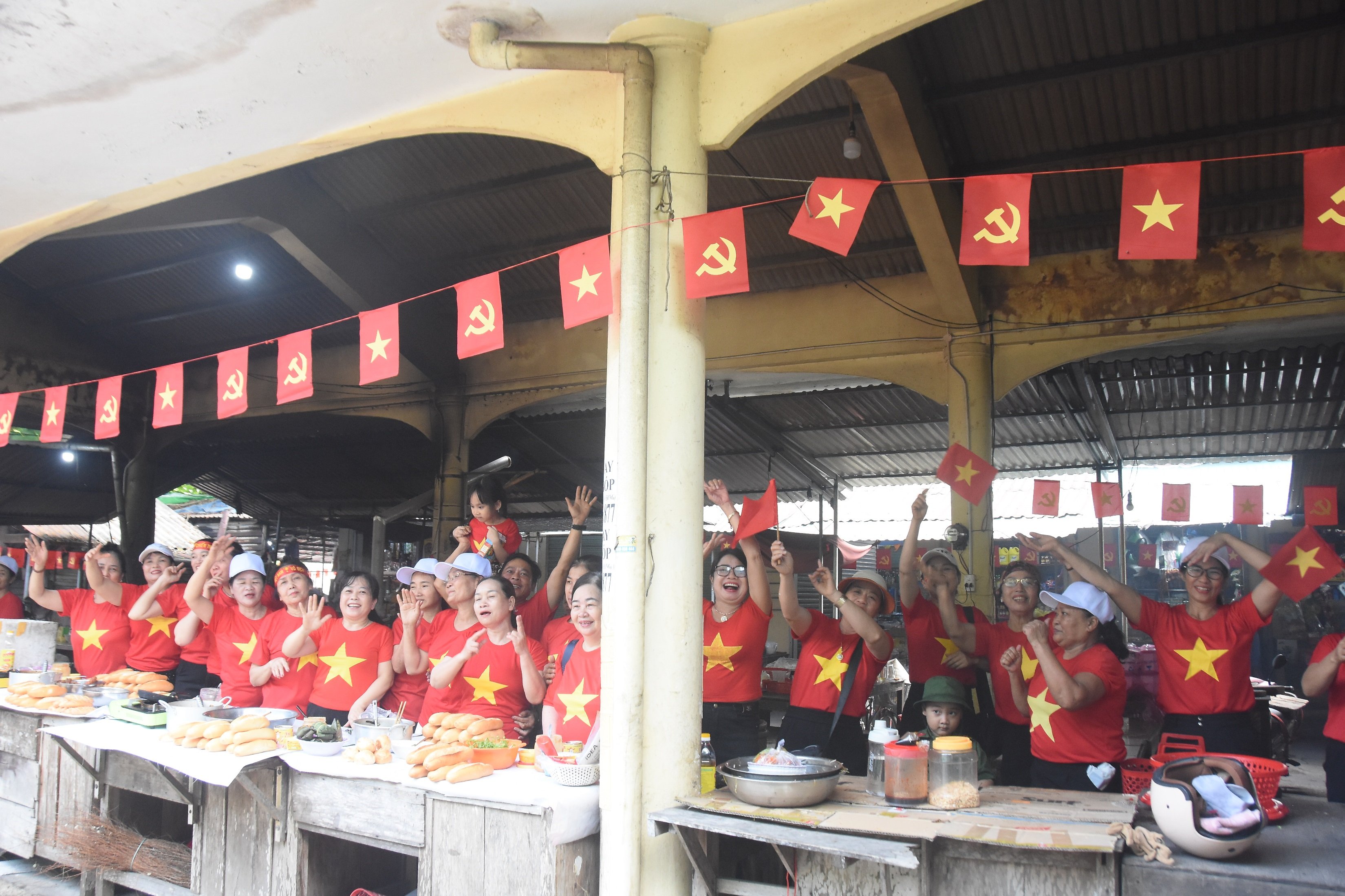 អាជីវករផ្សារ Lai Phuoc រាប់រយនាក់ពាក់អាវក្រហមជាមួយតារាពណ៌លឿង ដើម្បីអបអរសាទរពិធីបុណ្យដ៏អស្ចារ្យរបស់ប្រទេស។