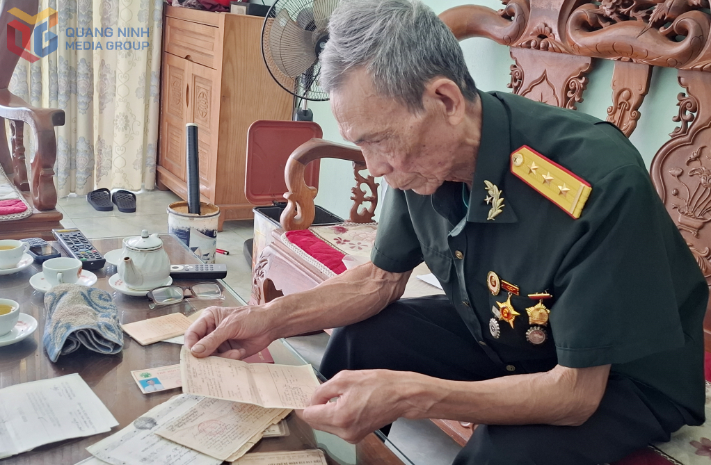 CCB Ngô Tiến Ninh tìm lại những tư liệu ông còn lưu giữ trong chiến tranh. Ảnh: Tư liệu