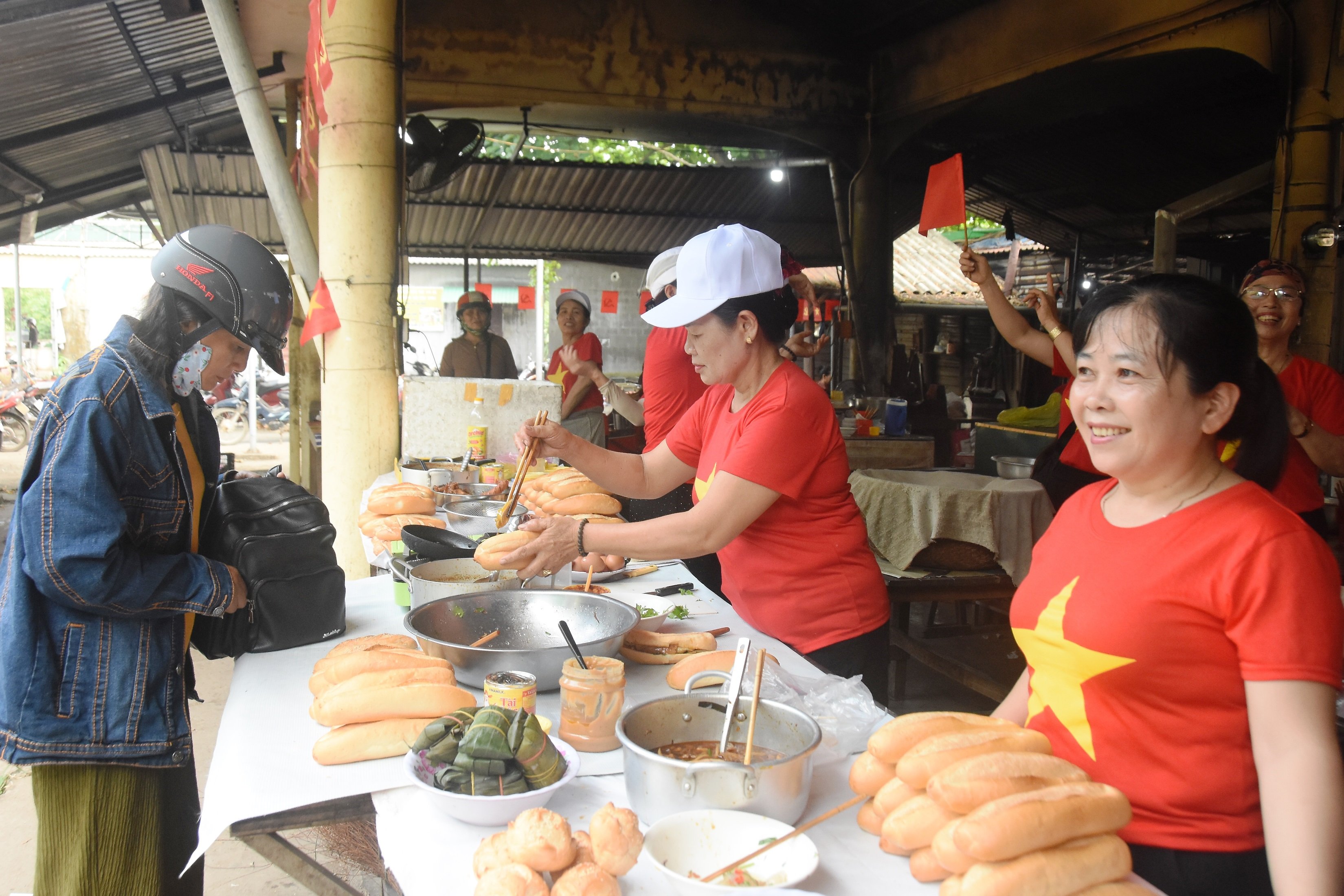 អាជីវករផ្សារ Lai Phuoc រាប់រយនាក់ពាក់អាវក្រហមជាមួយតារាពណ៌លឿង ដើម្បីអបអរសាទរពិធីបុណ្យដ៏អស្ចារ្យរបស់ប្រទេស។