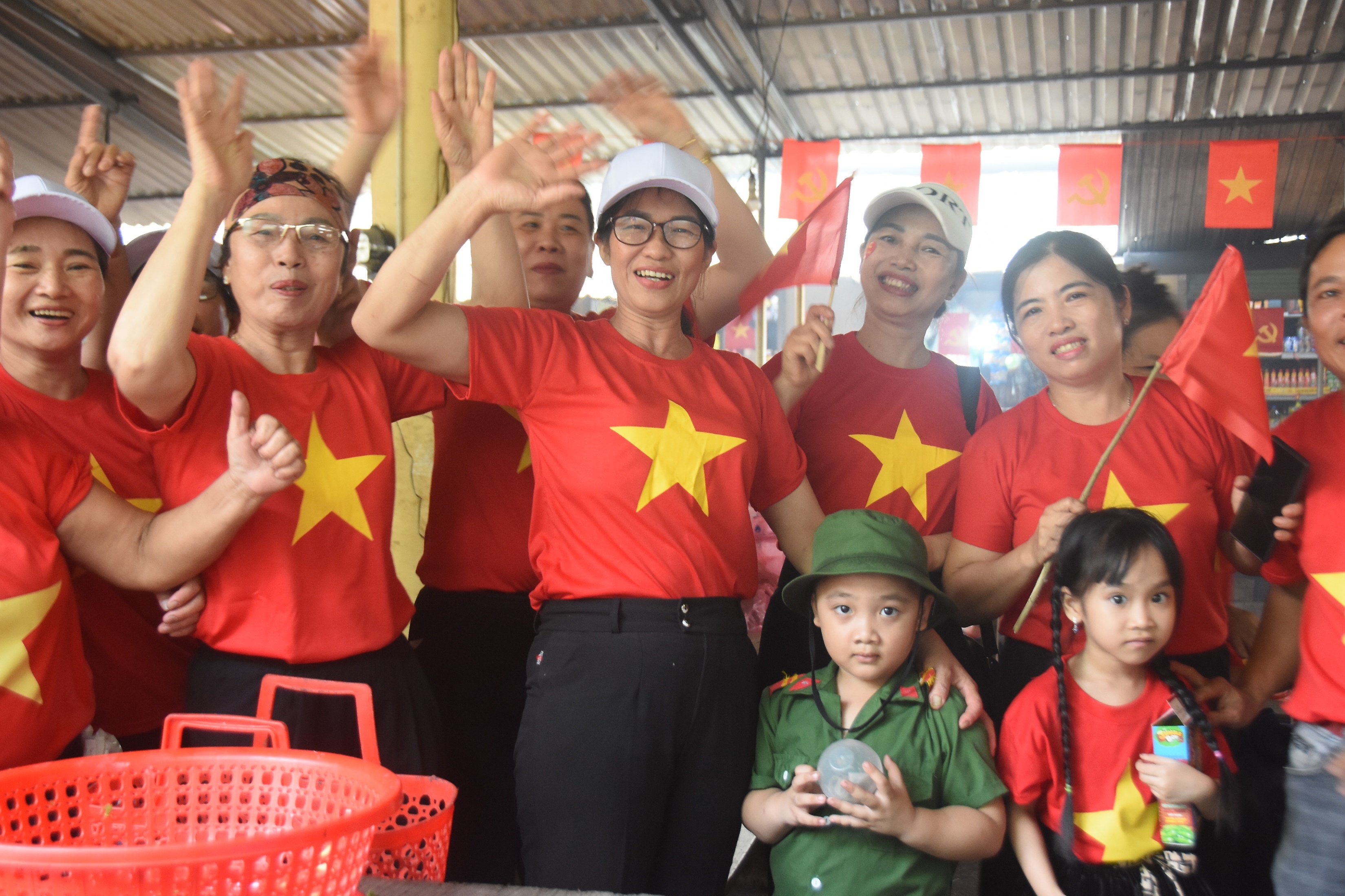 អាជីវករផ្សារ Lai Phuoc រាប់រយនាក់ពាក់អាវក្រហមជាមួយតារាពណ៌លឿង ដើម្បីអបអរសាទរពិធីបុណ្យដ៏អស្ចារ្យរបស់ប្រទេស។