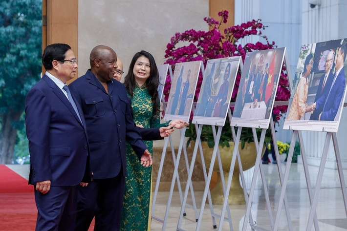 Thủ tướng Phạm Minh Chính và Tổng thống Burundi Évariste Ndayishimiye tham quan trưng bày ảnh về quan hệ hợp tác giữa hai nước. Ảnh: VGP/Nhật Bắc