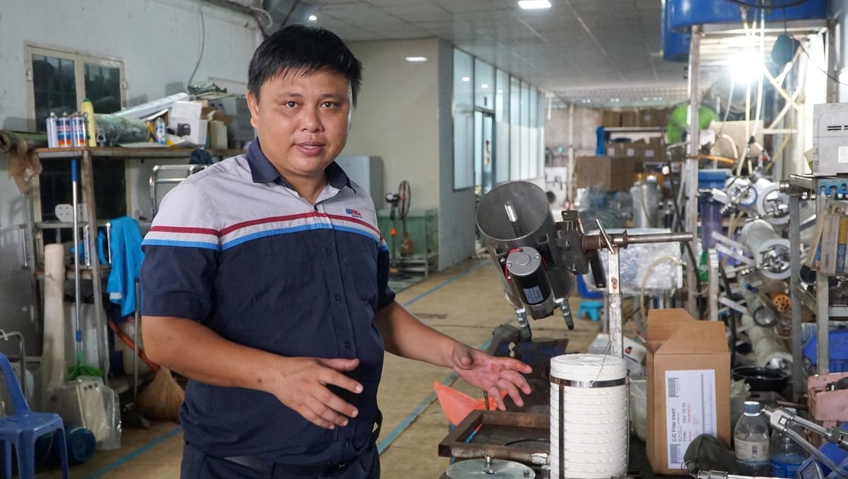 Anh Trần Thái Sơn, Giám đốc Công ty TNHH Hiệp lực Phát triển Việt, đang giới thiệu về thiết bị lọc dầu, giúp tiết kiệm chi phí nguyên liệu cho các tàu cá. Ảnh: Lê Bình.