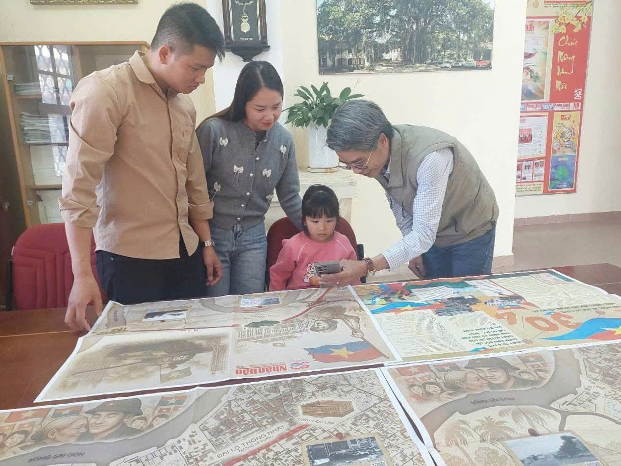 Nhà báo Mai Văn Bảo - Trưởng Văn phòng đại diện Báo Nhân Dân tại Lâm Đồng hướng dẫn bạn đọc quét mã QR để trải nghiệm các nội dung trên phụ san đặc biệt