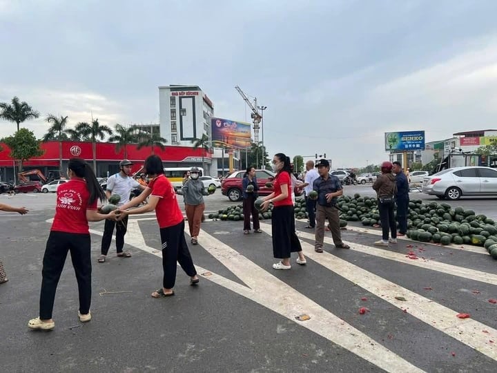 Người dân giúp tài xế thu gom dưa hấu bị đổ ra đường.