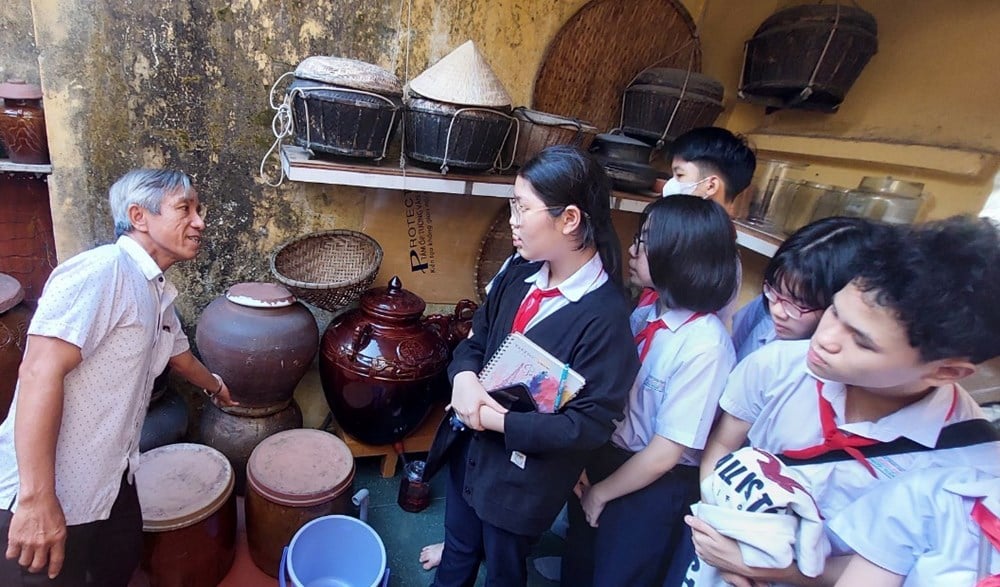 Ông Mười giảng giải cho học sinh về nghề làm mắm của ngư dân Mân Thái.  Ảnh: Tư liệu
