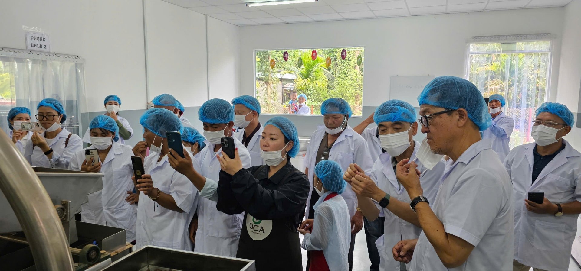 Ông Nozawa Hiroki – Giám đốc Công ty OCA Nhật Bản cùng cộng sự (thứ 2 từ phải qua) dẫn đoàn HTX Ca cao hữu cơ Đam Rông tham quan quy trình chế biến ca cao 