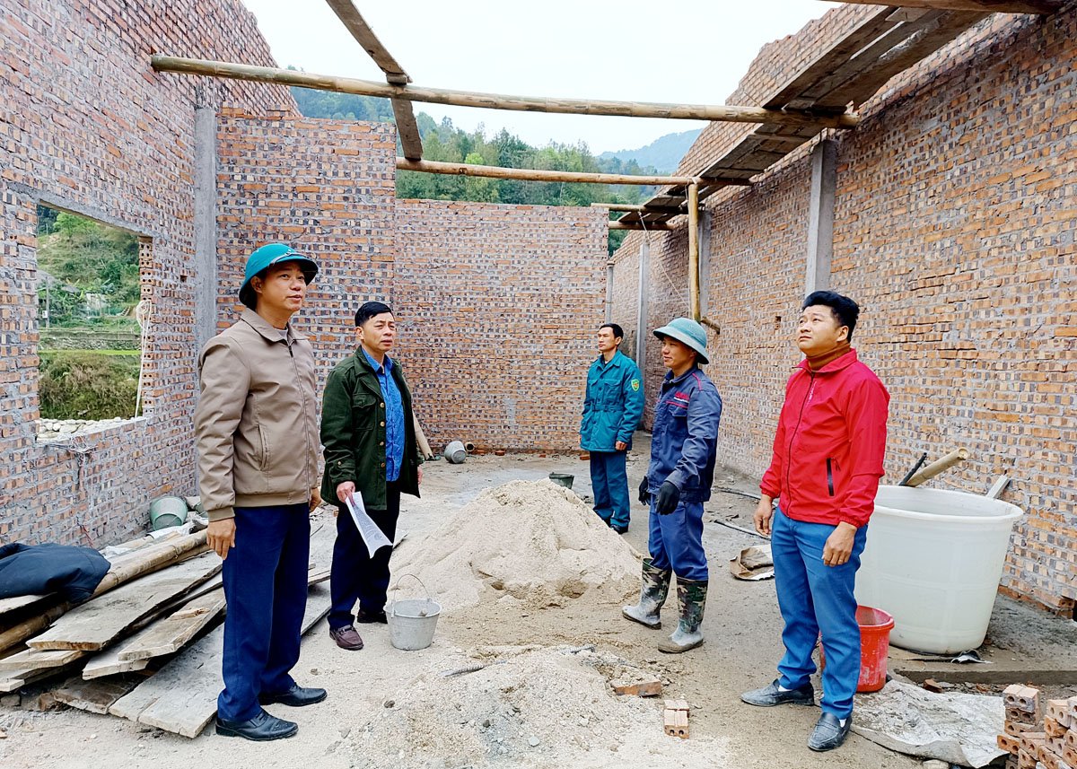 Lãnh đạo xã Bản Nhùng kiểm tra tiến độ xây dựng nhà ở cho người dân bị thiệt hại do thiên tai.