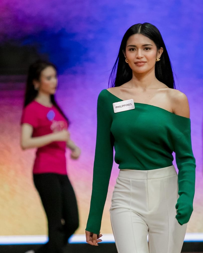 Krishnah Gravidez, người Philippines, phối áo lệch vai với quần vải. Cô thuộc nhóm ứng viên tiềm năng được các chuyên trang sắc đẹp đánh giá cao. Mỹ nhân từng đoạt danh hiệu Miss Charm Philippines 2023. Krishnah Gravidez đang theo học ngành kỹ thuật xây dựng, làm người mẫu, kinh doanh.