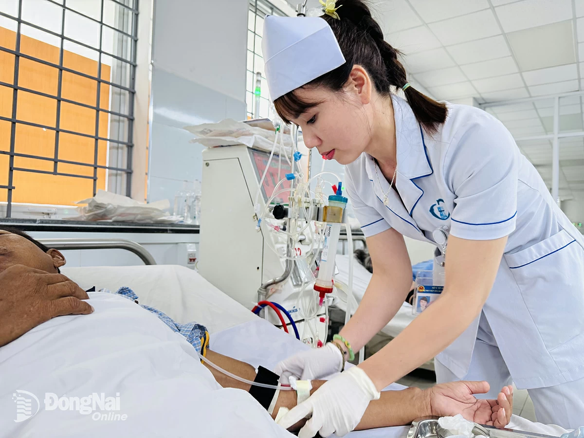 Điều dưỡng Lê Thị Lan (Khoa Thận nhân tạo, Bệnh viện Đa khoa Thống Nhất) thực hiện kỹ thuật chạy thận cho bệnh nhân. Ảnh:H.Dung

