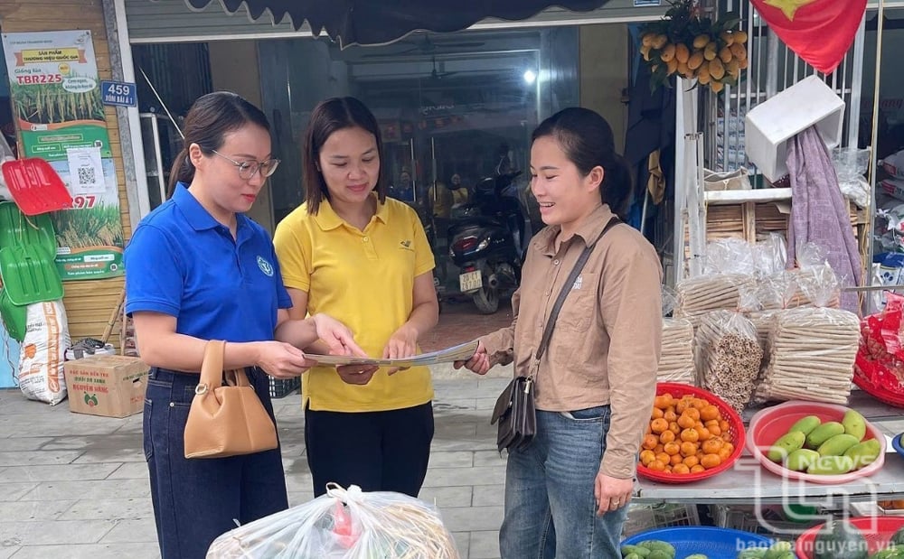 Cán bộ Bảo hiểm xã hội tuyên truyền về quyền lợi khi tham gia bảo hiểm y tế, bảo hiểm xã hội tại chợ Bảo Cường (Định Hóa).