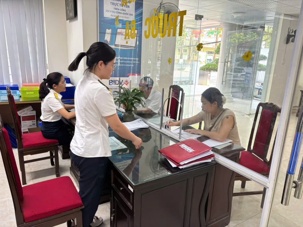 Cán bộ Đội thuế liên huyện Thành phố - Thạch An hướng dẫn người dân kê khai thuế trước bạ.