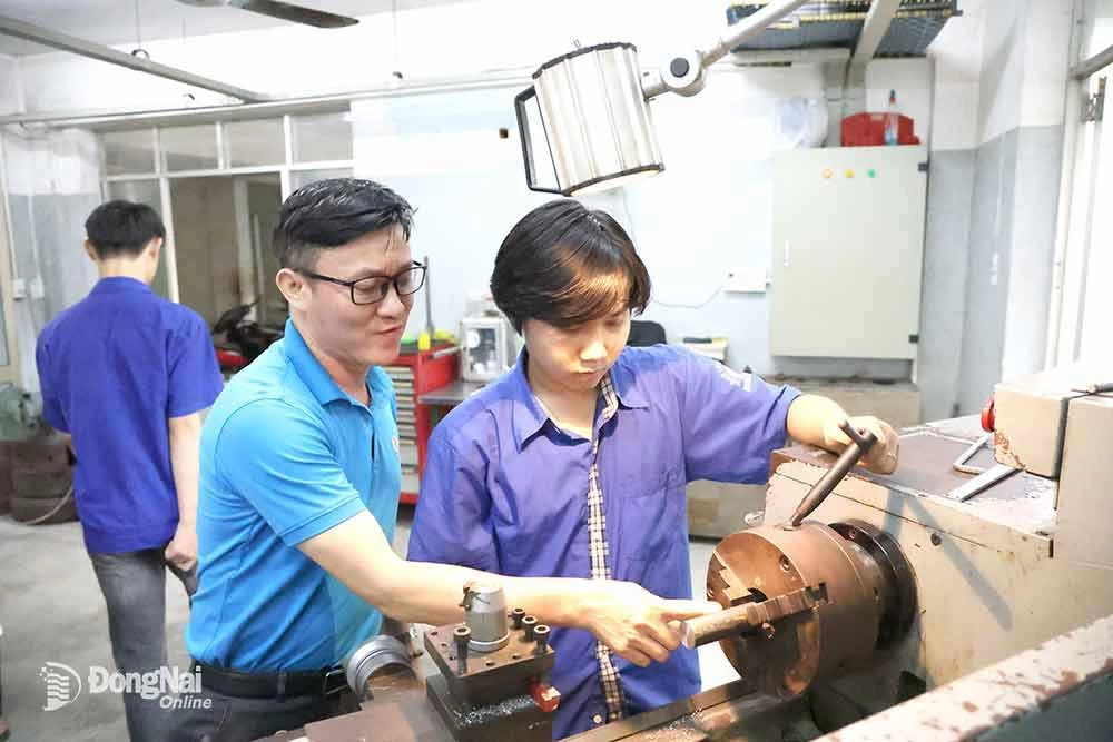 សាស្ត្រាចារ្យនៃមហាវិទ្យាល័យវិជ្ជាជីវៈសេដ្ឋកិច្ចឌីជីថល 2 (ទីក្រុង Bien Hoa) ណែនាំសិស្សអំពីរបៀបធ្វើការលើម៉ាស៊ីនកាត់ដែក CNC ។ រូបថត៖ C. Nghia