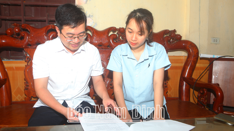Cán bộ Ngân hàng Chính sách xã hội huyện Nam Trực (trái) hướng dẫn hộ vay vốn sản xuất, kinh doanh.