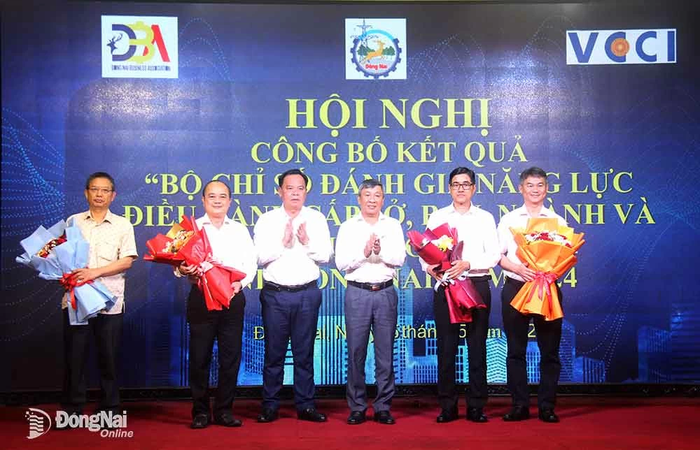 Phó bí thư thường trực Tỉnh ủy Hồ Thanh Sơn và Phó bí thư Tỉnh ủy, Chủ tịch UBND tỉnh Võ Tấn Đức tặng hoa chúc mừng các sở, ban, ngành, địa phương trong tỉnh có chỉ số năng lực cạnh tranh cao trong năm 2024. Ảnh: H.Quân