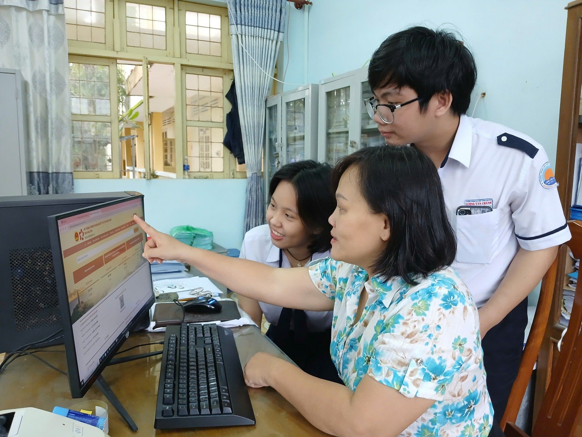 Giáo viên Trường THPT chuyên Lương Văn Chánh hướng dẫn học sinh thực hiện thủ tục hành chính trên Cổng Dịch vụ công. Ảnh: TRUNG HIẾU