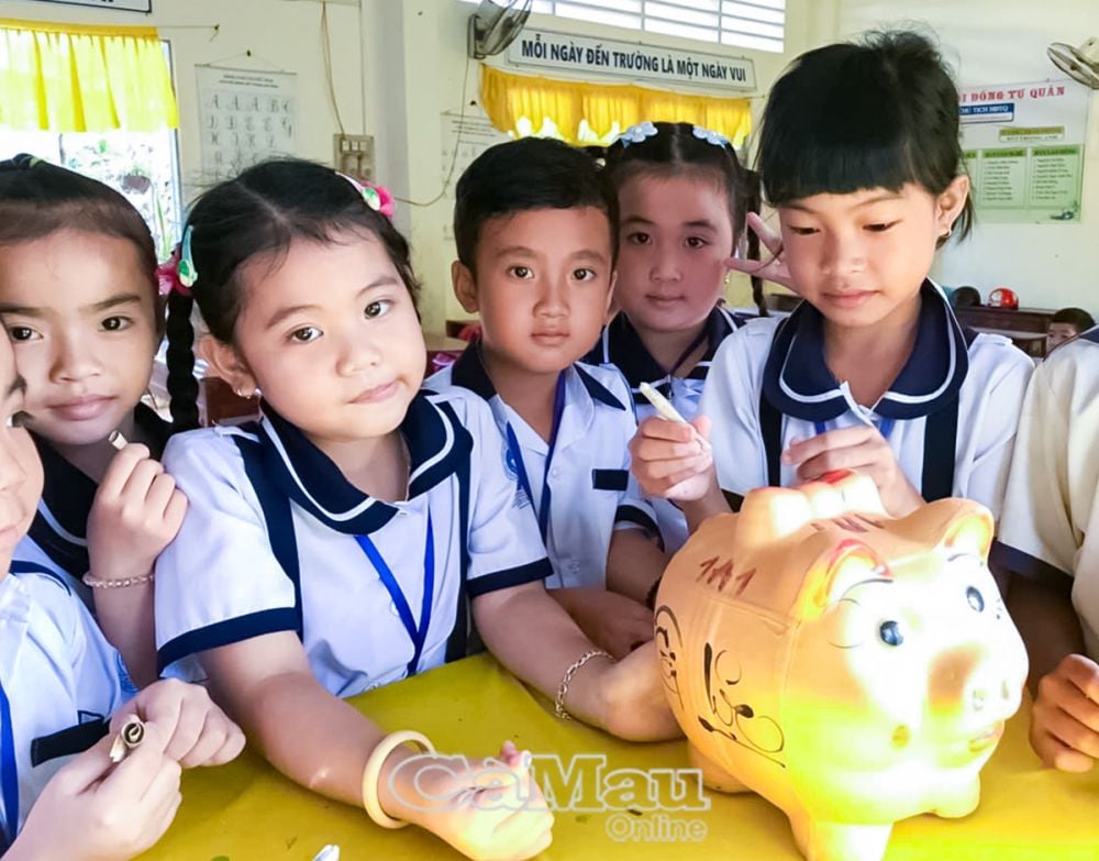 Các em học sinh Trường Tiểu học Võ Thị Sáu, xã Khánh Hoà, huyện U Minh cùng nhau tiết kiệm tiền lẻ nuôi heo đất - hoạt động giàu tính nhân văn nhằm giúp đỡ bạn bè có hoàn cảnh khó khăn tiếp tục đến trường.