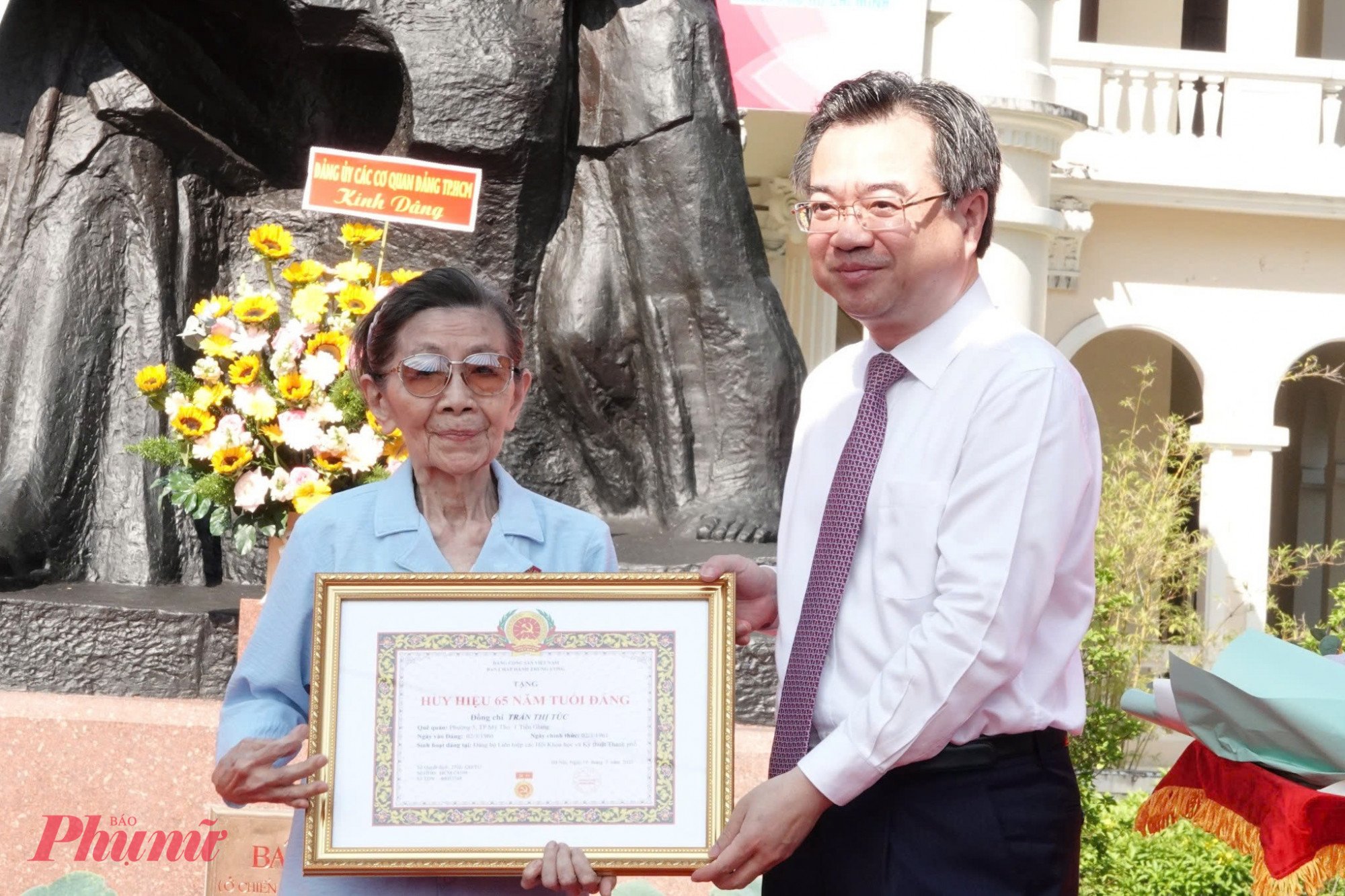 Ông Nguyễn Thanh Nghị trao huy hiệu 65 năm tuổi Đảng cho đảng viên Trần Thị Túc.