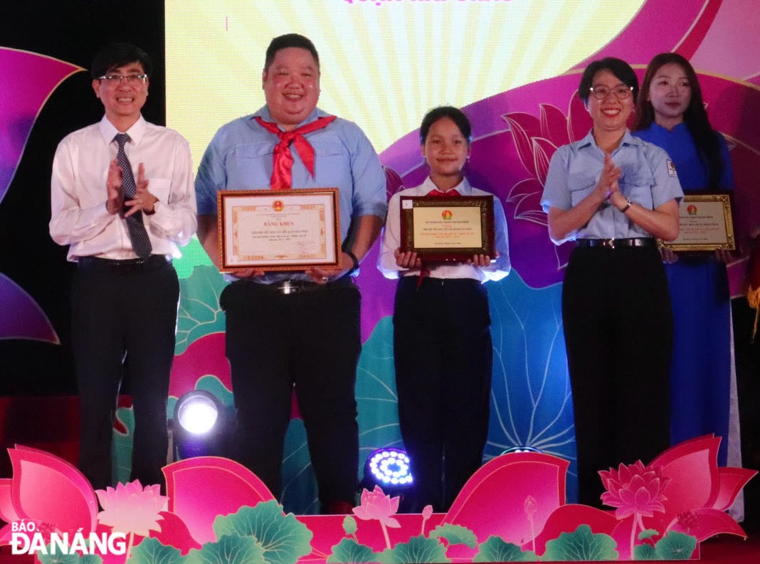 Trưởng ban Tuyên giáo và Dân vận Thành ủy Trần Thắng Lợi (bìa trái) trao giải thưởng “Liên đội xuất sắc - nghìn việc tốt”. Ảnh: KHÁNH NGÂN