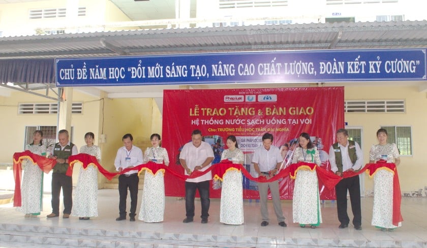 Các đại biểu thực hiện nghi thức cắt băng khánh thành Hệ thống lọc nước lọc cho Trường Tiểu học Trần Đại Nghĩa (xã Khánh Tiến, huyện U Minh).