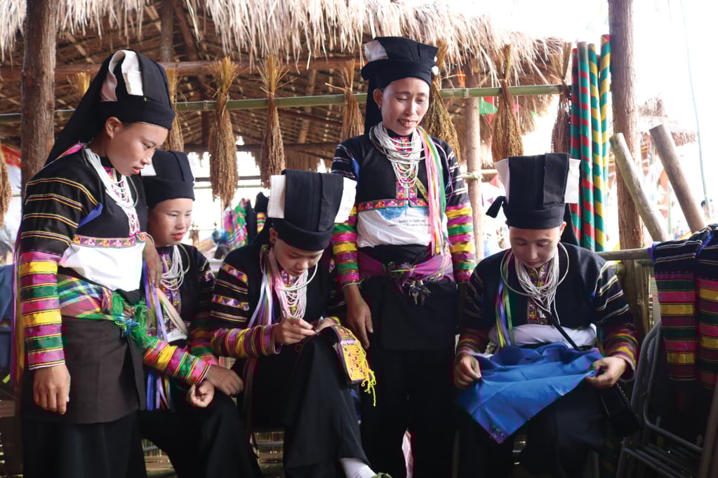 Phụ nữ dân tộc Lô Lô đen tự tay cắt, khâu trang phục của mình.