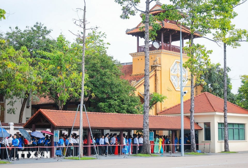 Các đoàn đại biểu di chuyển trên đường Hùng Vương để vào Lăng viếng Chủ tịch Hồ Chí Minh. (Ảnh: Hoàng Hiếu/TTXVN)