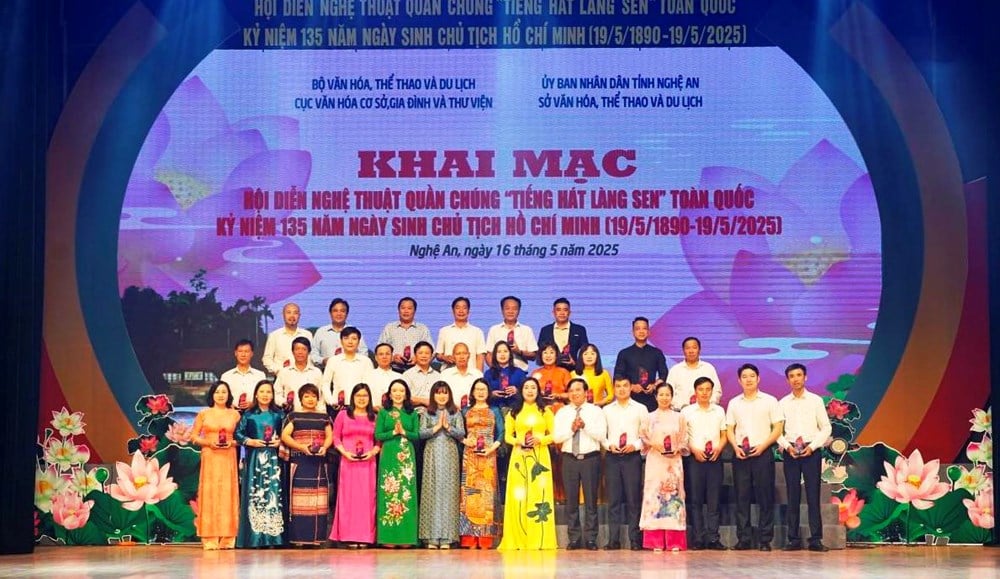 ตัวแทนคณะศิลปกรรมมวลชนได้รับสัญลักษณ์ที่ระลึกจากคณะกรรมการจัดงาน ภาพจาก : หนังสือพิมพ์วัฒนธรรม