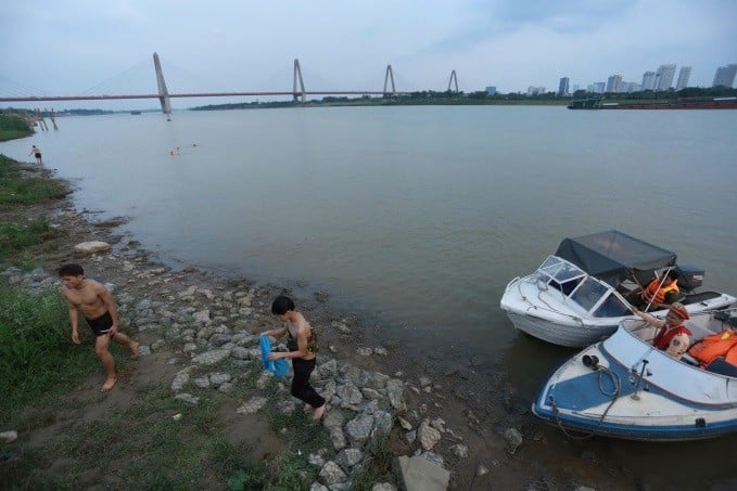 CSGT và lực lượng chức năng xã Vĩnh Ngọc huyện Đông Anh nhắc nhở người dân không bơi lội tại các khu vực nguy hiểm trên sông Hồng.