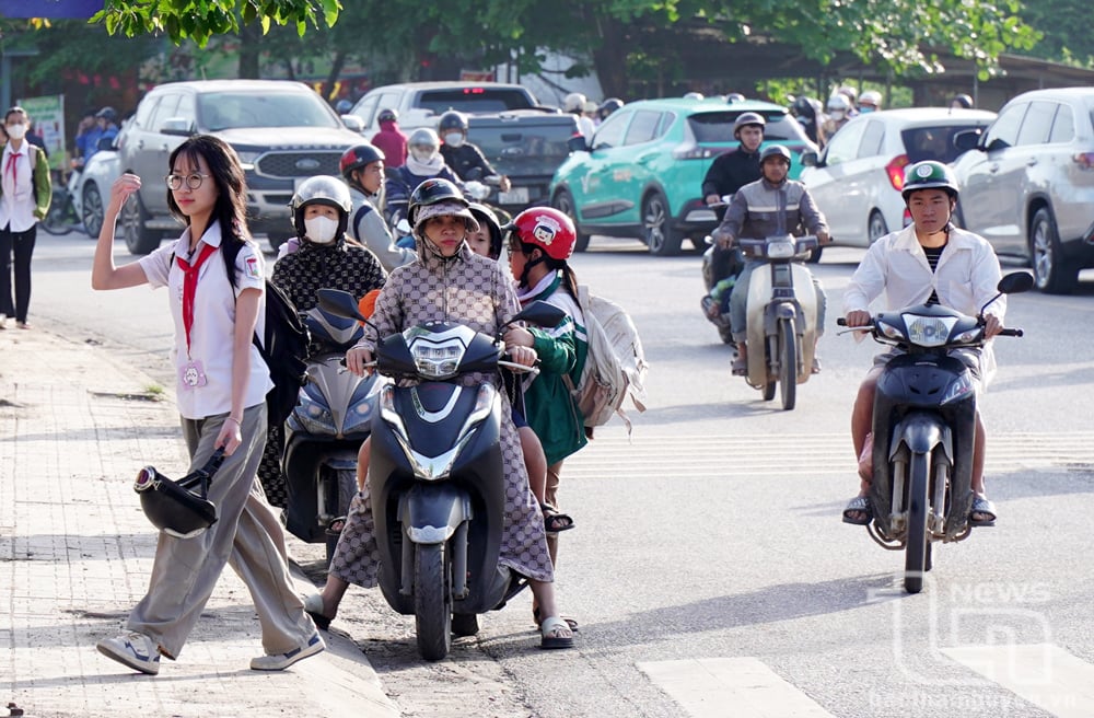 Nhiều phụ huynh dành thời gian đưa đón con đi học, thay vì để các em chưa đủ điều kiện điều khiển phương tiện giao thông đến trường. Ảnh: Mạnh Hùng