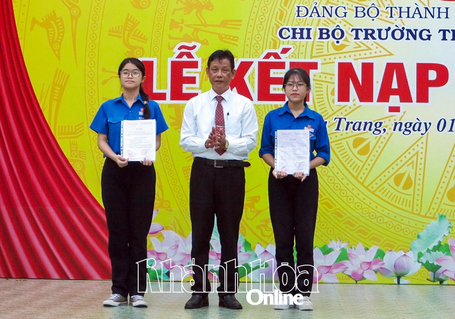 Thầy Trương Minh Trình trao quyết định kết nạp đảng viên cho 2 học sinh.