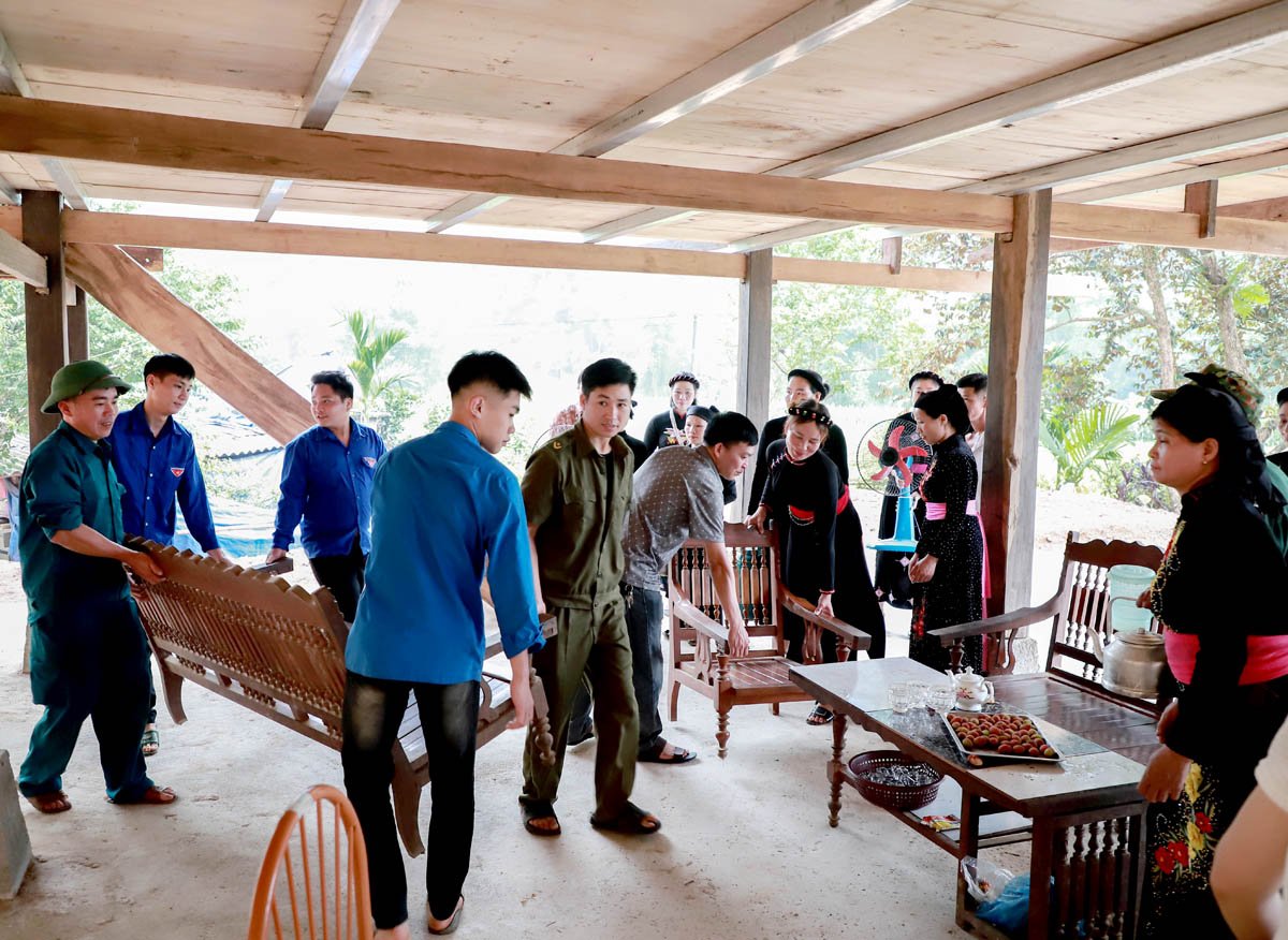 Các lực lượng và bà con thôn Nà Han, xã Yên Định (Bắc Mê) hỗ trợ gia đình người có công Mai Trung Liên vào nhà mới.